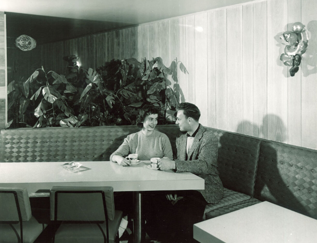 Prompt B. A couple students stare into each other’s eyes as they sit together in a booth while holding mugs.